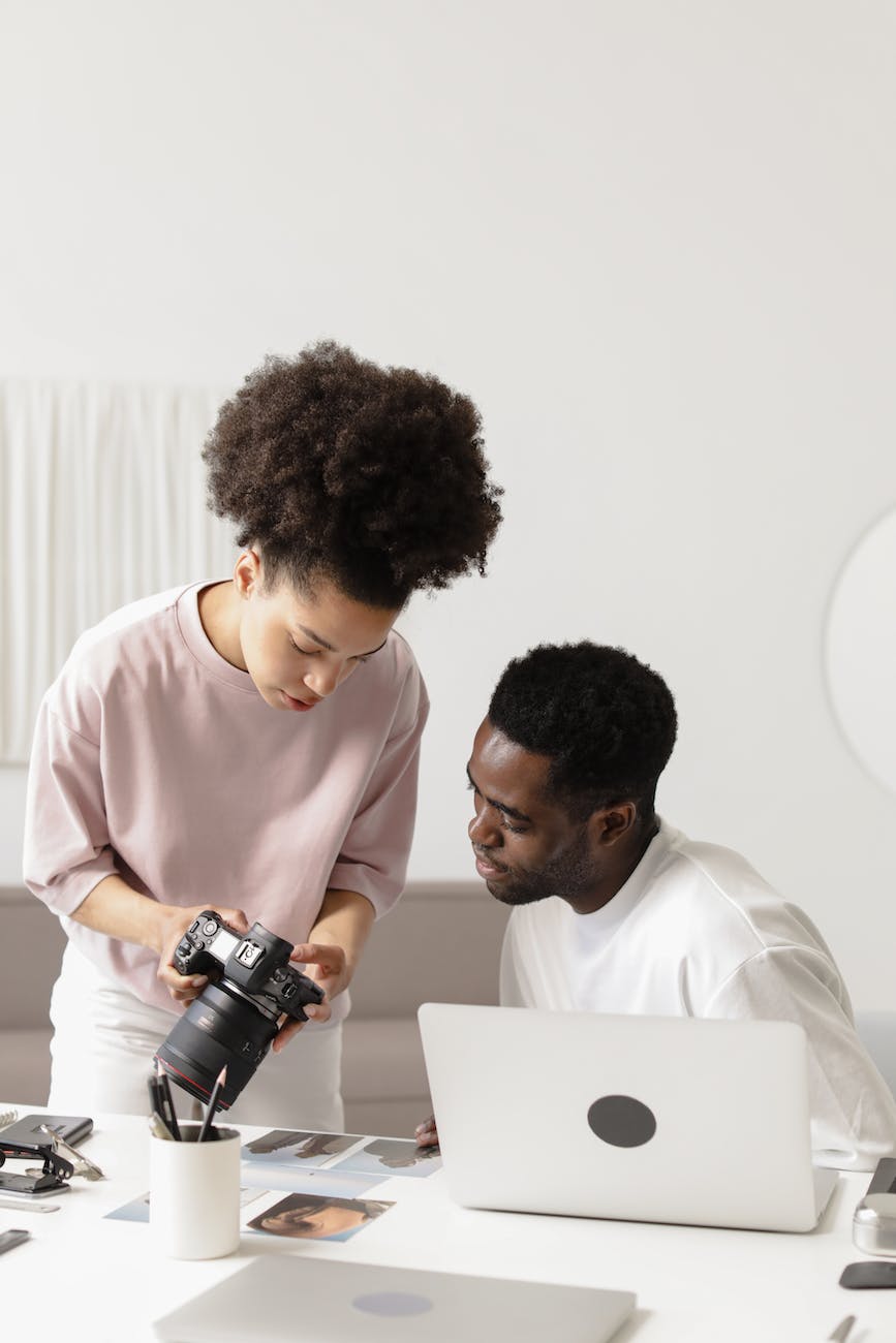 woman showing the camera shots to the man - lifestyle creator